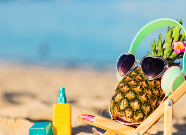 Sommerbild mit Ananas am Strand im Liegestuhl