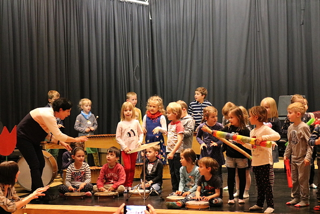Kinder musizieren mit verschiedenen Instrumenten auf der Bühne der Musikschule Feldkirch.
