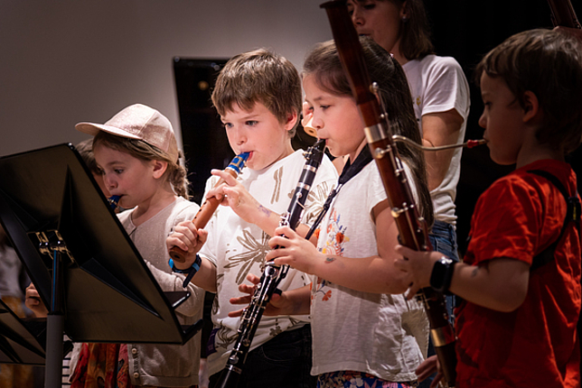 Eine kleine Gruppe von Kindern spielt auf ihren Instrumenten. 